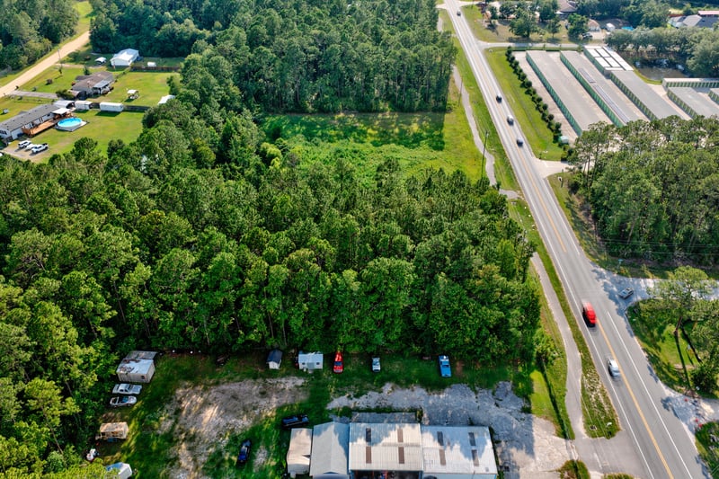 Aerial of storage buildings bordered by trees and the roadway at 4393 Co Rd 218, Middleburg, FL 32068