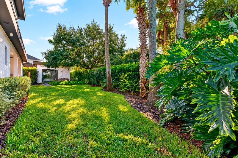 Backyard lawn with manicured grass and tropical landscaping at 722 3rd Ave N, Jacksonville Beach, FL
