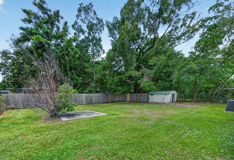 Backyard with trees and storage shed at 6238 Randia Dr, Jacksonville, FL 32210