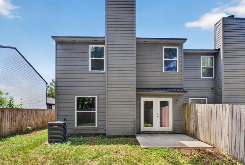 Rear exterior with two-story gray siding and patio doors at 4427 Millstone Ct, Jacksonville, FL