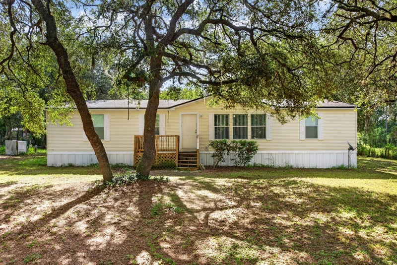 Front exterior shaded by oak trees at 3215 Robin Ln, Middleburg, FL