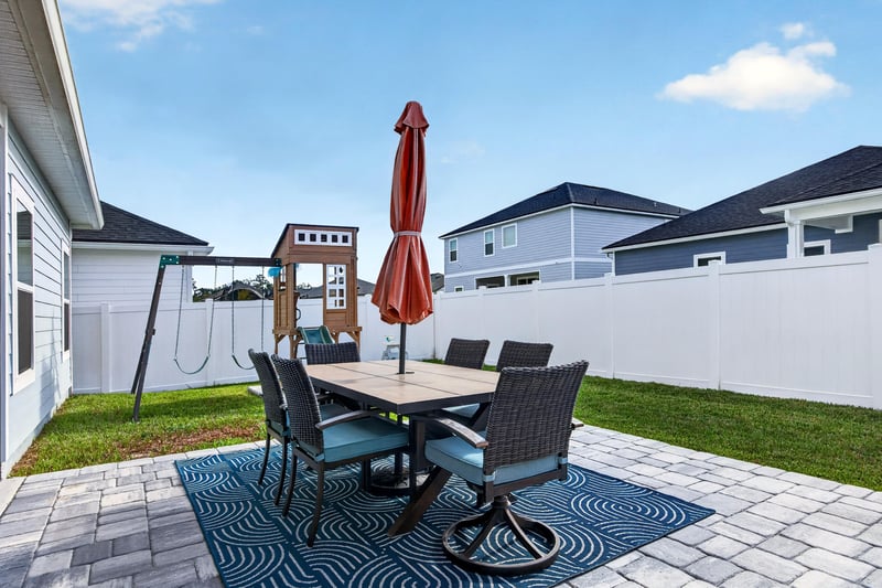 Backyard patio with table, umbrella and play set at 2354 Jennings Farm Dr, Middleburg, FL 32068