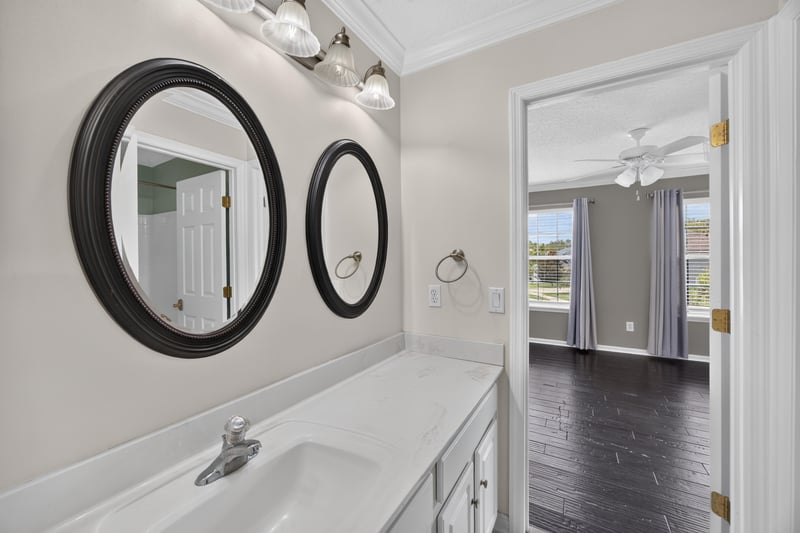 Bathroom with double sink vanity and round mirrors at 1493 Greyfield Dr, St. Augustine, FL 32092