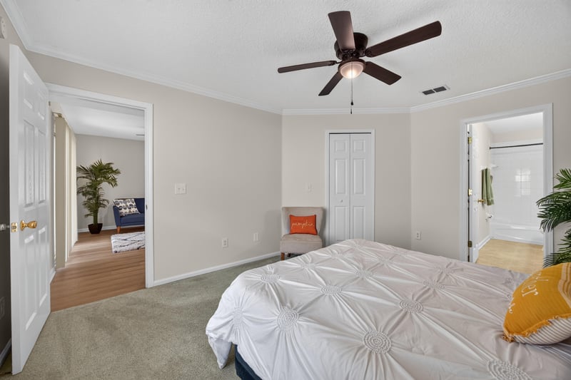 Primary bedroom with ceiling fan and bath entry at 605 N Covered Bridge Rd, Jacksonville, FL