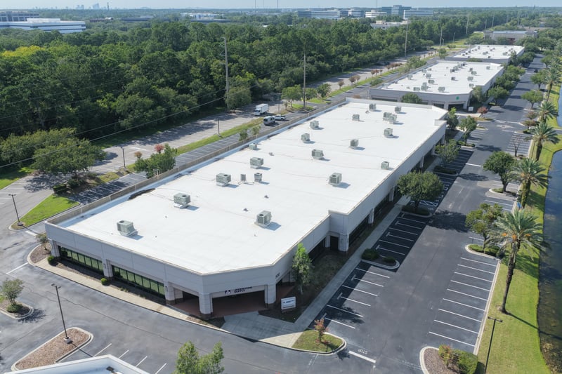 Aerial view of a building roofline and parking lot at 10550 Deerwood Park Blvd, Jacksonville, FL 32256