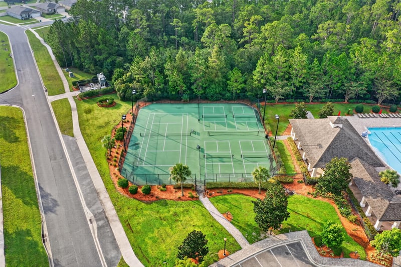 Drone view of tennis courts and pool area in River Glen