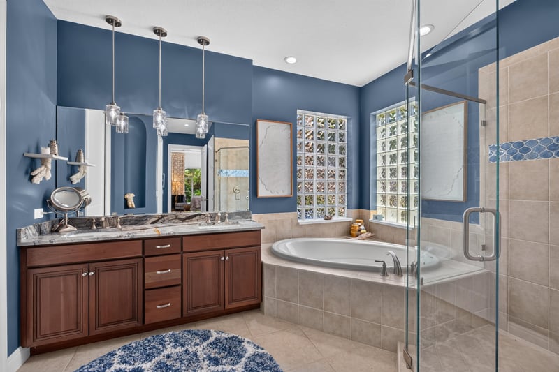 Primary bathroom with glass-block window and tub at 140 Ave De La Mer, Palm Coast, FL 32137