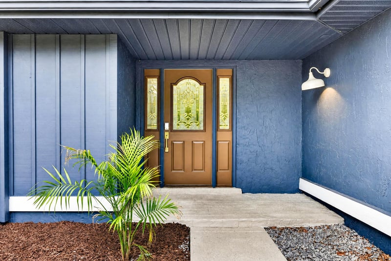 Front entry with wood door and potted plant at 551 Deltona Blvd, St. Augustine, FL 32086