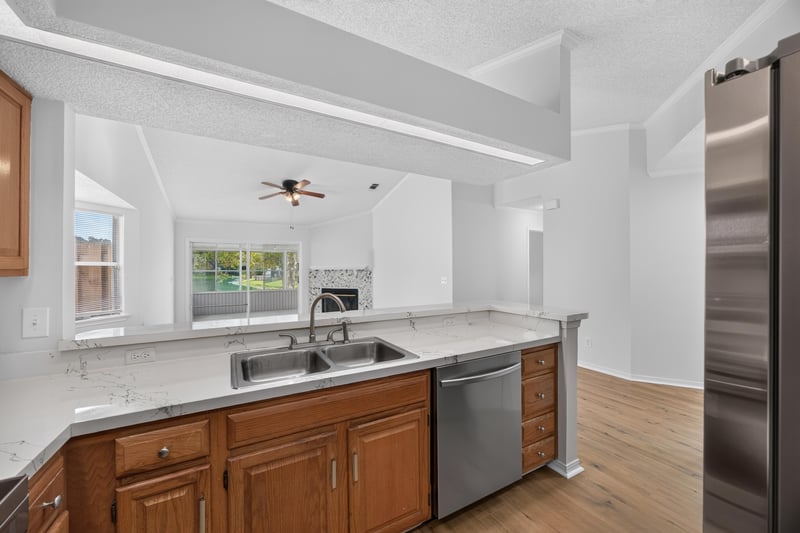 Kitchen island with granite counters and dishwasher at 8047 Mactavish Way E, Jacksonville, FL 32244