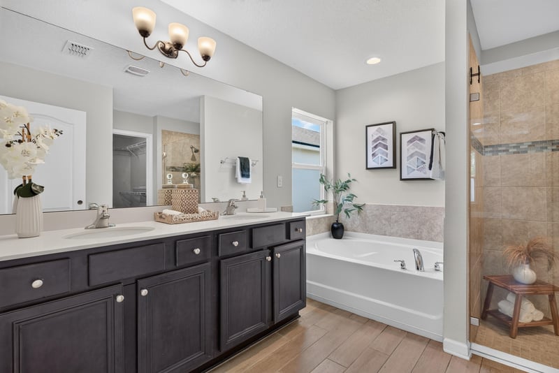 Primary bathroom with soaking tub and dark cabinetry at 10066 Andean Fox Dr, Jacksonville, FL 32222
