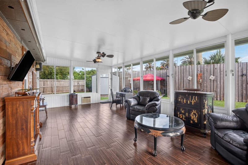 Sunroom with wood plank flooring and seating at 6931 Cane Grass Ln E, Jacksonville, FL 32244