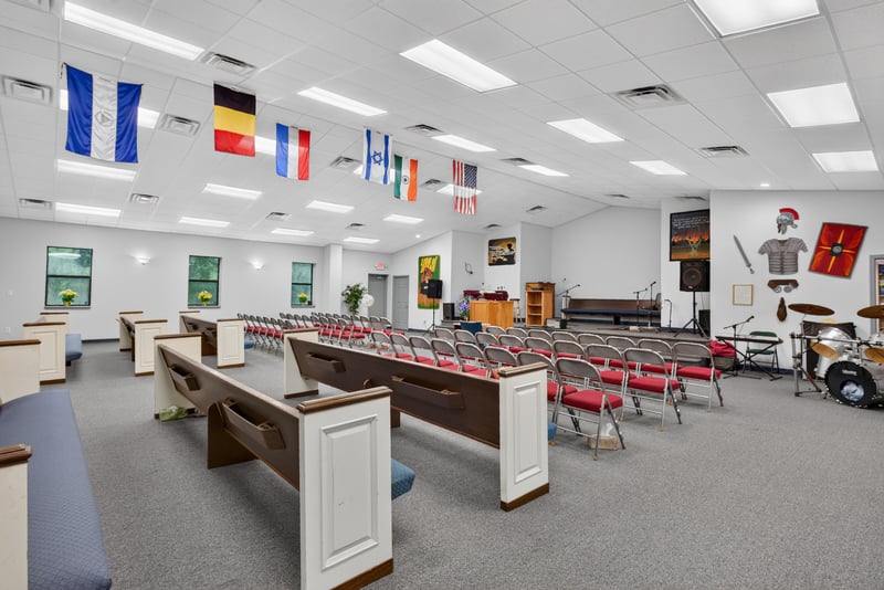 Assembly hall view toward stage with podium and pews at 1038 County Rd 315, Melrose