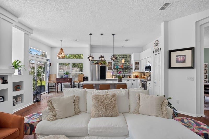 Family room with white sofa and vaulted ceiling at 1820 Burgess Hill Dr E, Jacksonville, FL