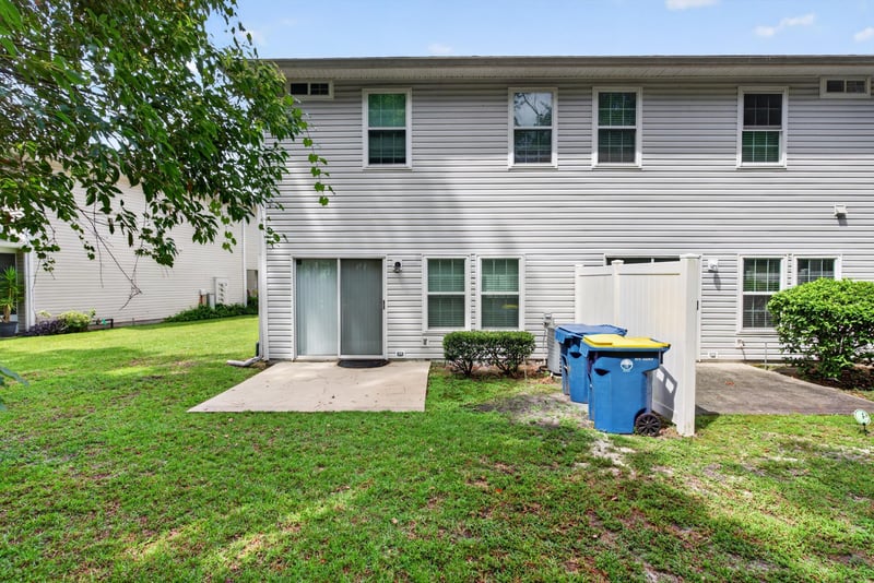 Backyard with patio and recycling bins at 12359 Mangrove Forest Ct, Jacksonville, FL 32218