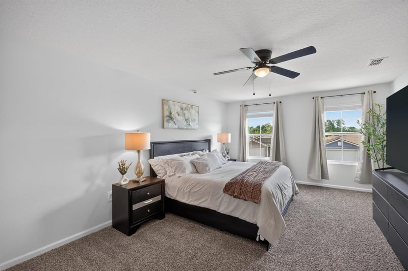 Bedroom with ceiling fan and large window at 65255 Frst Glen Ln, Yulee, FL 32097