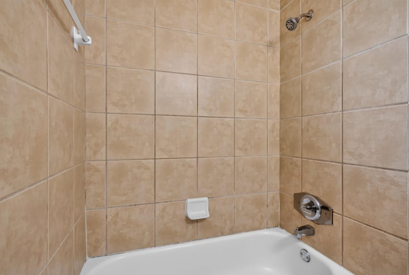 Bathroom tile shower and tub at 1928 Montmarte Dr, Jacksonville, FL 32210