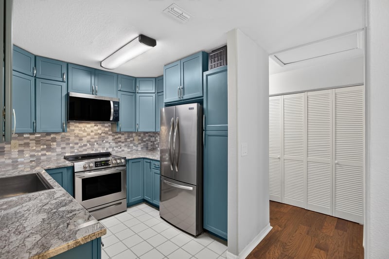 Kitchen with blue cabinets and stainless steel appliances at 10150 Belle Rive Blvd, Jacksonville, FL