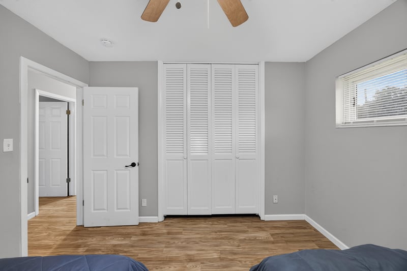 Hallway with closet doors and wood-look flooring at 9506 Harriet Ave, Jacksonville, FL 32208