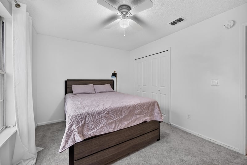 Bedroom with bed and closet doors at 8921 Needlepoint Pl, Jacksonville, FL 32244