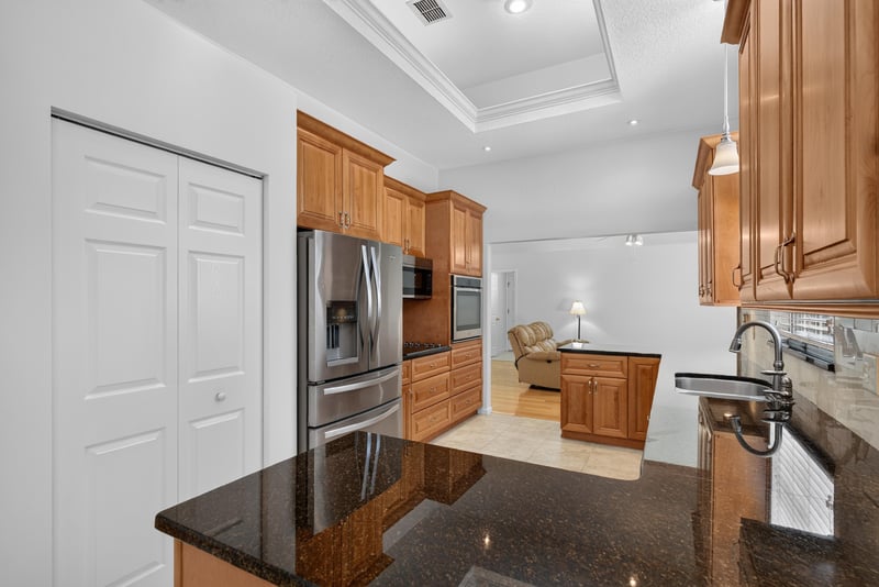 Kitchen with tray ceiling and island at 12810 Swamp Owl Ln