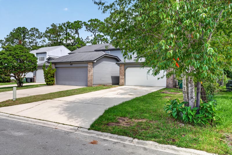 Front exterior view with driveway and mature trees at 4427 Millstone Ct, Jacksonville, FL