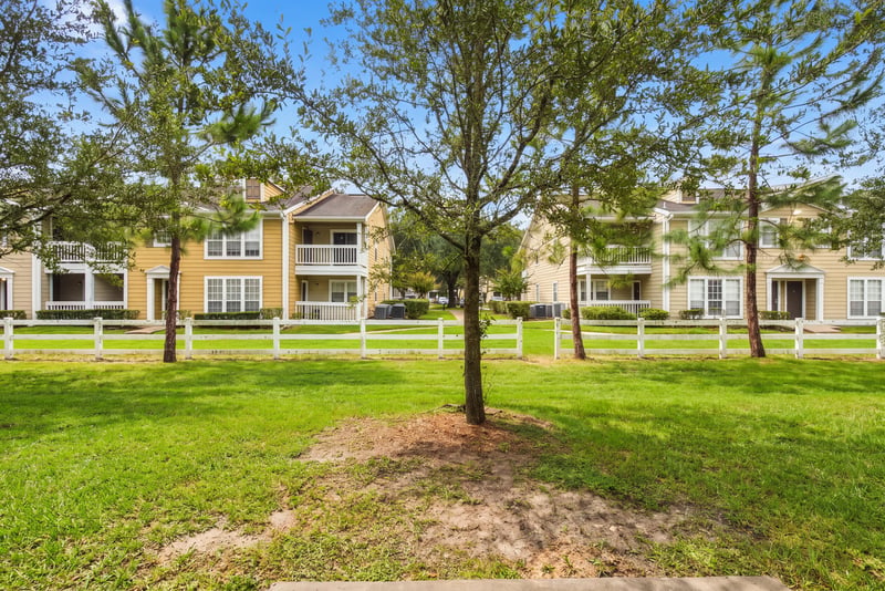 Grass area with trees and townhome buildings in Jacksonville, FL
