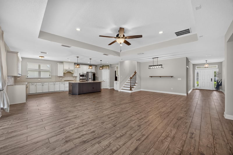 Open living and kitchen space with tray ceiling and staircase at 53 Lumen Ct, St. Augustine, FL 32095