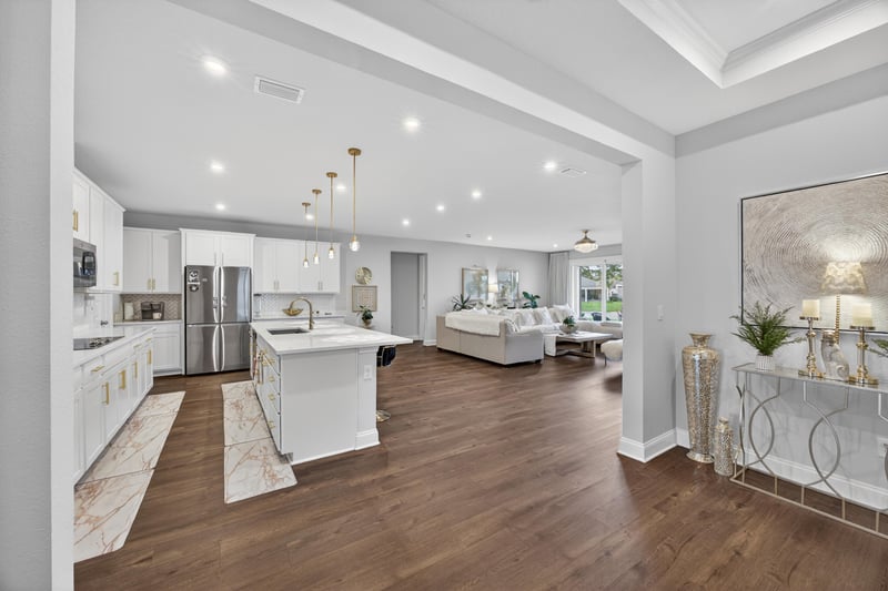 Open kitchen and living area with white cabinets and island at 85491 Fall River Pkwy, Fernandina Beach, FL 32034