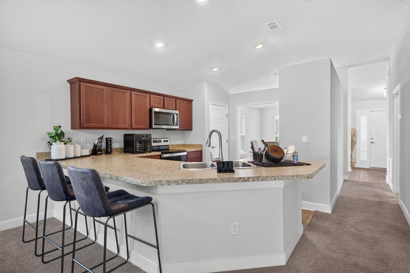 Kitchen with granite island and bar seating at 9846 Olivia St, Jacksonville, FL