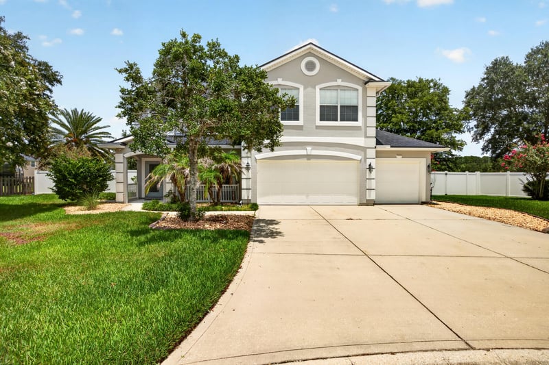 Front exterior with driveway and mature trees at 1493 Greyfield Dr, St. Augustine, FL 32092