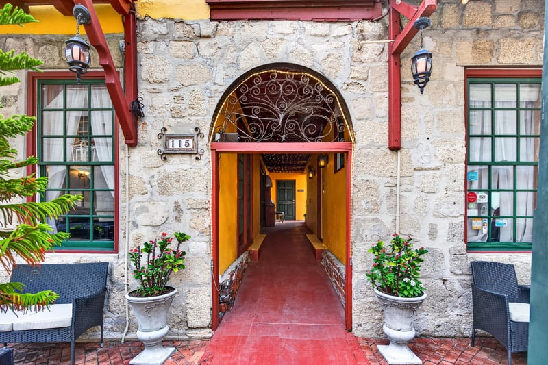 Covered entry walkway with an arched stone doorway at 115 Cordova St, St. Augustine, FL
