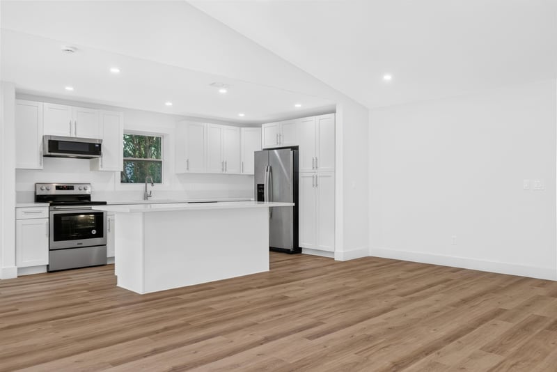 Kitchen island with stainless range and white cabinets at 8453 Boysenberry Ln W, Jacksonville, FL