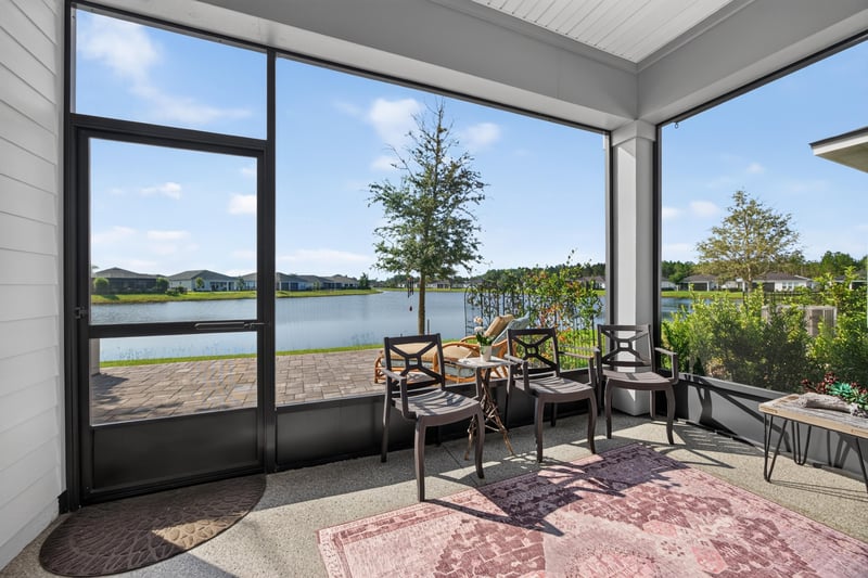 Screened porch with lake view and seating at 129 Amberwood Dr, St. Augustine, FL
