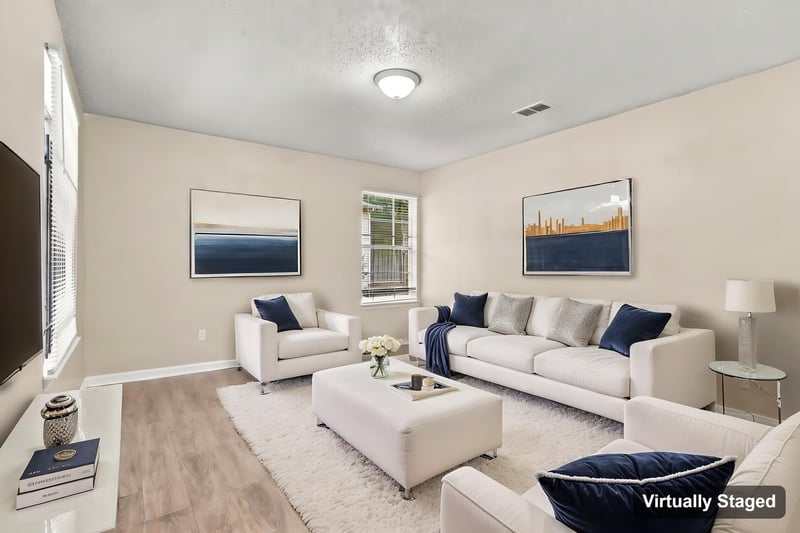 Living room with sofa and wood-look flooring, virtually staged, at 219 Shortreed St, Jacksonville, FL 32254