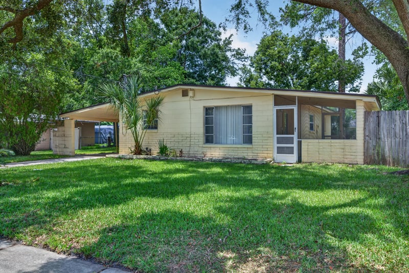 Front exterior angle showing carport and mature trees at 5527 Beney Rd, Jacksonville, FL 32207