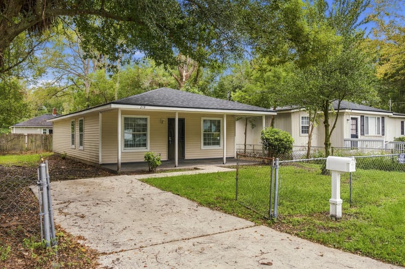 Front exterior showing driveway and chain link fence at 219 Shortreed St, Jacksonville, FL 32254