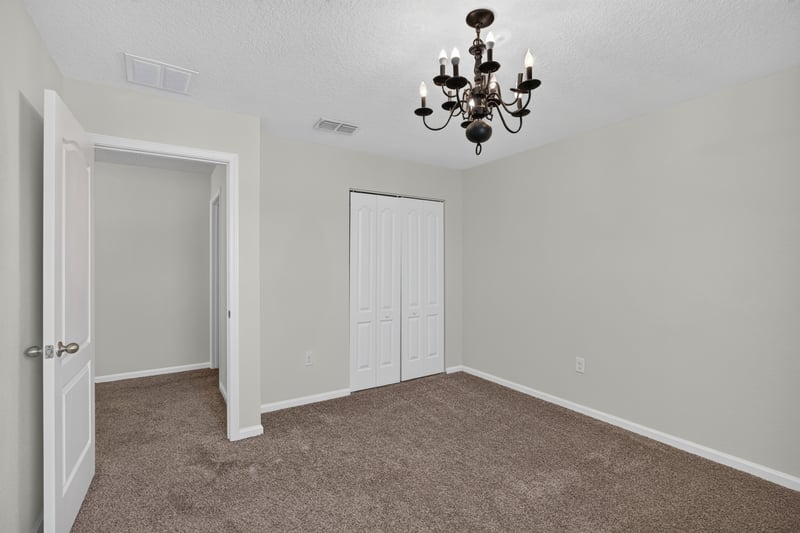Bedroom with closet doors and chandelier at 6830 Hanford St, Jacksonville, FL 32219