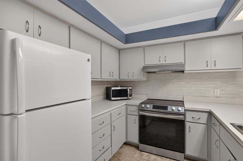 Kitchen with side-by-side refrigerator and tile backsplash at 2910 Ravines Rd, Middleburg, FL 32068