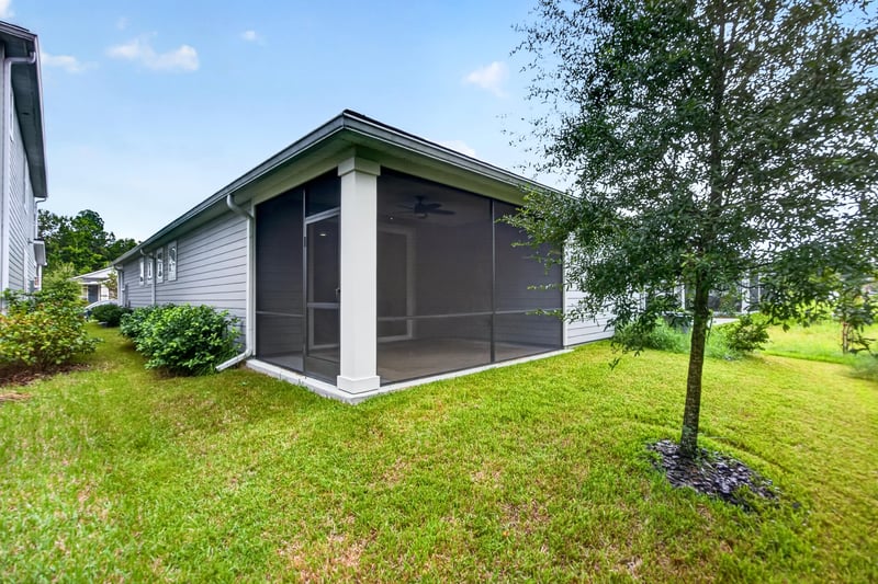 Screened lanai and backyard lawn at 93 Lochloosa Ct, St. Johns, FL 32259