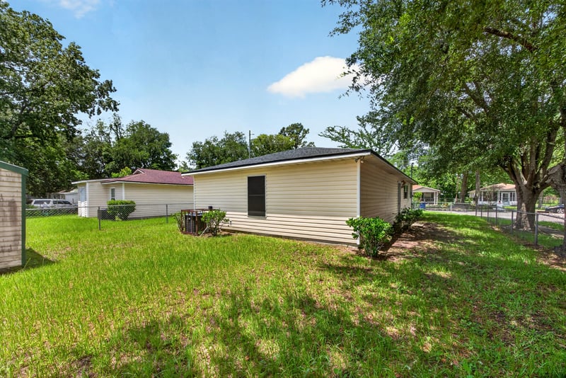 Backyard view with grass and trees at 5375 Dodge Rd, Jacksonville, FL 32209