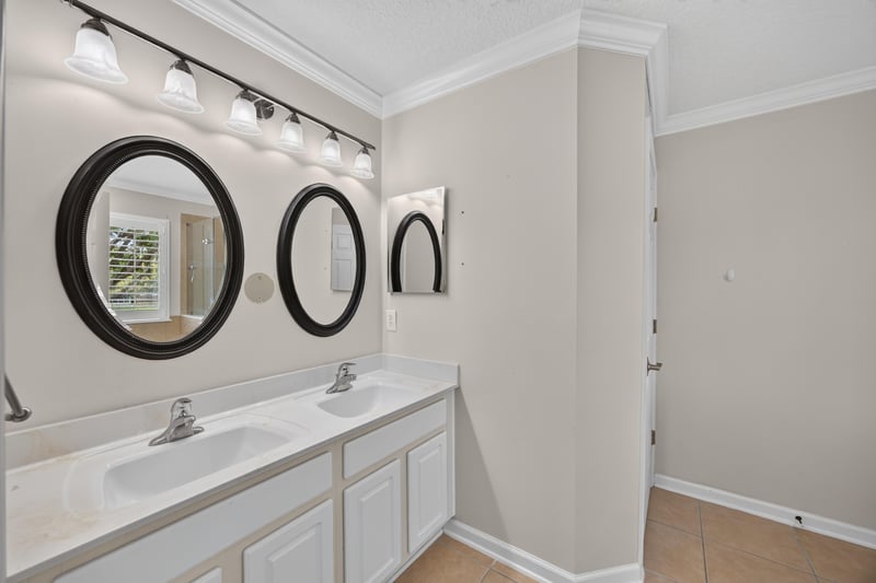 Primary bathroom with double sink vanity and round mirrors at 1493 Greyfield Dr, St. Augustine, FL 32092