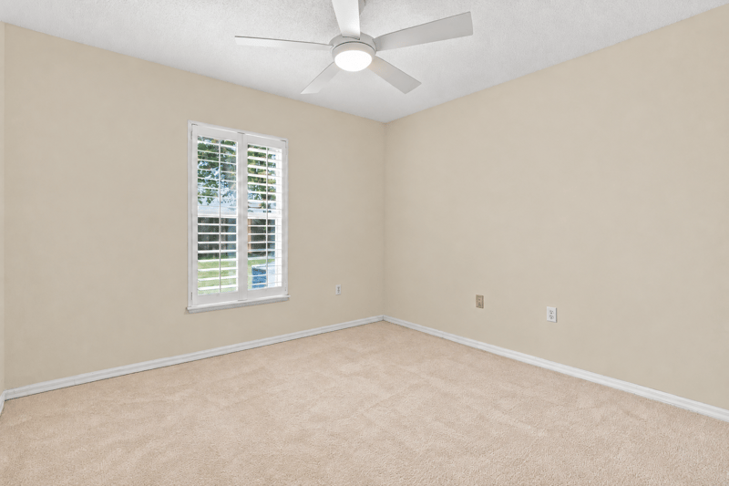 Bedroom with plantation shutters and carpet at 11197 Illford Dr