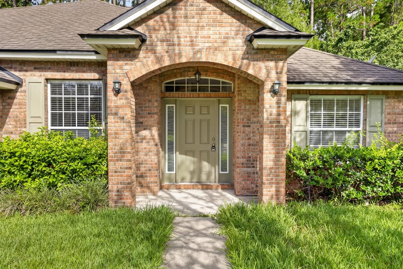 Front entry with sidelight windows and landscaping at 299 John's Creek Pkwy, St. Augustine, FL 32092