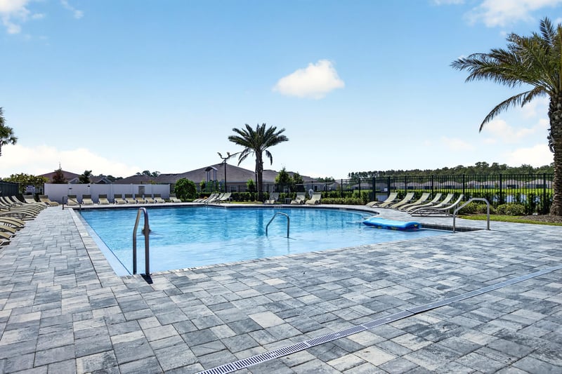 Community pool with loungers and palm trees in Highland Chase