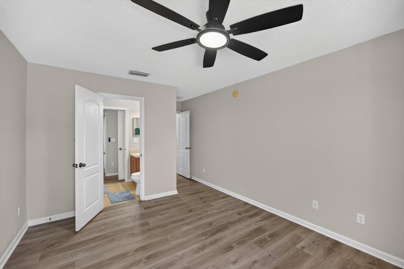 Bedroom with multiple doors and ceiling fan at 7723 Playschool Ln, Jacksonville, FL