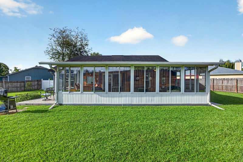 Backyard with sunroom and open lawn at 6931 Cane Grass Ln E, Jacksonville, FL 32244