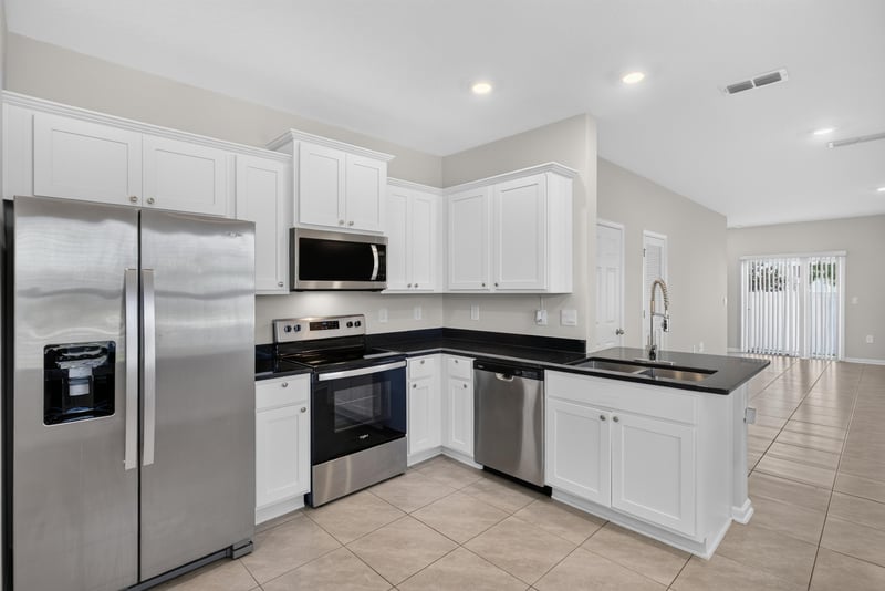 Kitchen with white cabinets and black countertops at 4024 Bay Hawk Ct, Jacksonville, FL