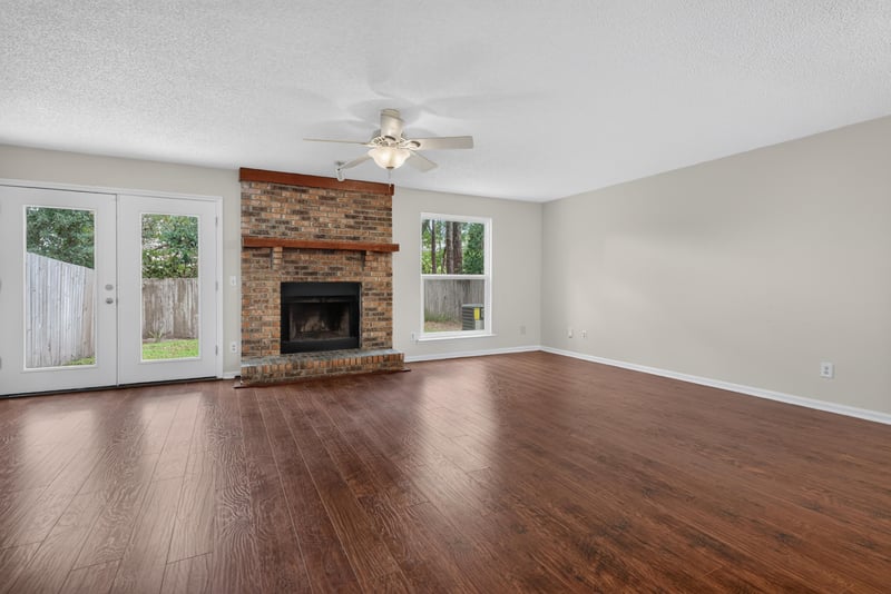 Living room with brick fireplace and French doors at 4427 Millstone Ct, Jacksonville, FL