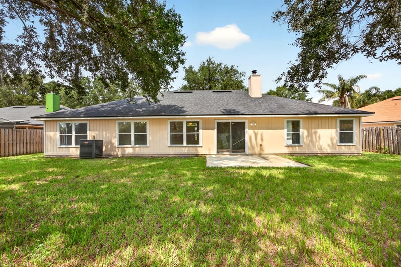 Back exterior with chimney and open lawn at 456 Bay Point Way N, Jacksonville, FL 32259