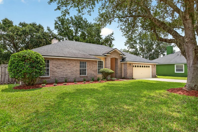 Front exterior from across the street with brick facade at 456 Bay Point Way N, Jacksonville, FL 32259